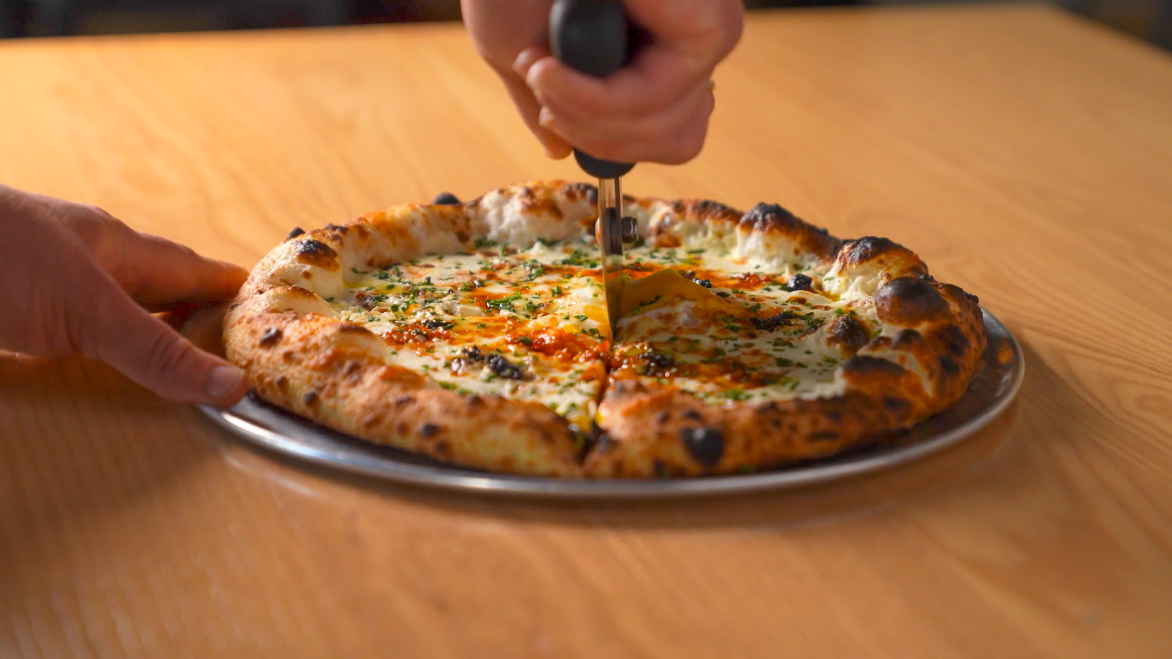 Pizza being cut at Bar Torino